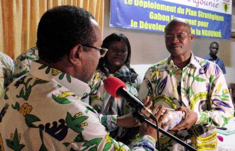 Guy-Bertrand Mapangou (à gauche) remettant les 10 millions de francs CFA pour la caution d’Ali bongo au secrétaire général adjoint du PDG, Claude Dibady Mayila. © D.R.
