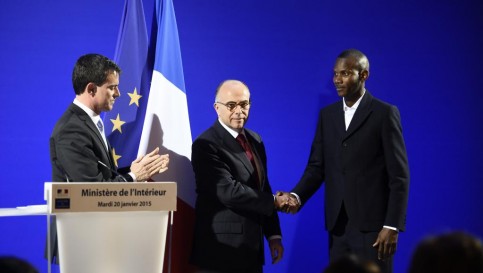Lassana Bathily lors de sa cérémonie de naturalisation française, place Beauvau à Paris, en présence du Premier ministre Manuel Valls et du ministre de l'Intérieur, Bernard Cazeneuve. AFP / ERIC FEFERBERG