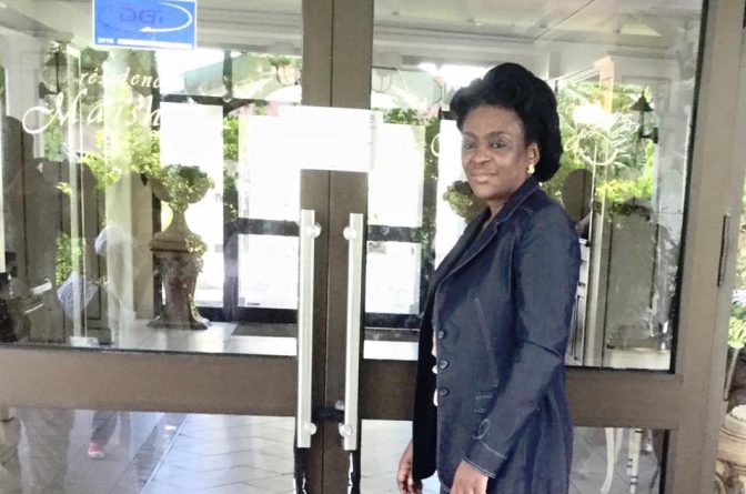 Chantal Myboto Gondjout montrant les scellés de la DGI sur la porte du Maïsha, le 22 mars 2016 à Libreville.
