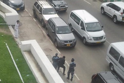 Junior Ebong Tchissambo, aux prises avec deux policier, le 28 novembre à Libreville. © Facebook/infoskinguele