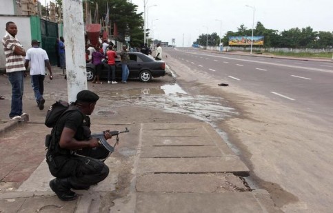Un officier de sécurité congolais sécurise la zone près de la télévision RTNC, prise d'assaut plus tôt dans la matinée, le 30 décembre 2013, à Kinshasa. (Photo Stringer. Reuters)