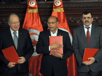 Le président de la République (c), le président de l’Assemblée nationale (g)et le Premier ministre sortant lors de la cérémonie de la signature de la Constitution, Tunis, le 27 janvier 2014. AFP PHOTO / FETHI BELAID